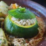 Ein gefüllter Zappo = runde Zucchini. Außen grün, innen gelblich. Ausgehöhlt und mit Reis gefüllt. Im Unterteiol einer traditionellen Tajine angerichtet.