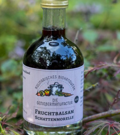 Fruchtbalsam Schattenmorelle bio in einer kleinen Flasche mit Logo der Genießermanufactur und Titel auf weißem Hozhintergrund